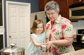 Grandmother showing grand daughter how to bake a cake